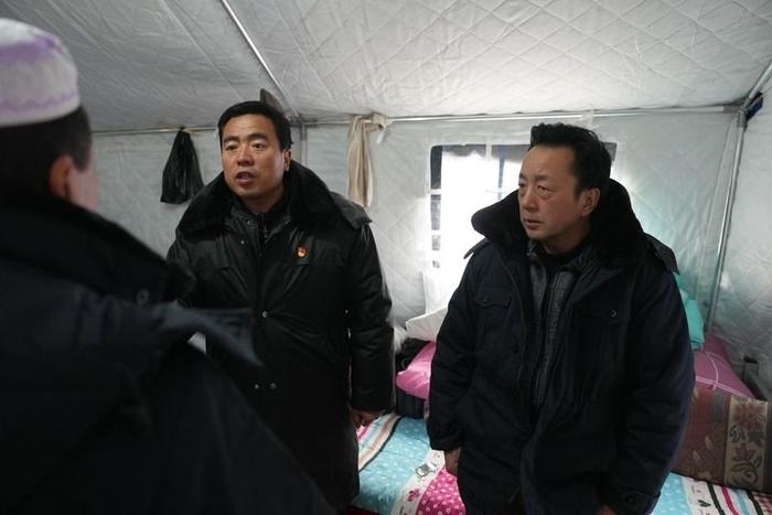 2023年12月22日，積石山縣大河家鎮(zhèn)大河村黨支部書記馬成忠（右二）在帳篷里和受災(zāi)群眾交流。新華社記者 陳斌 攝