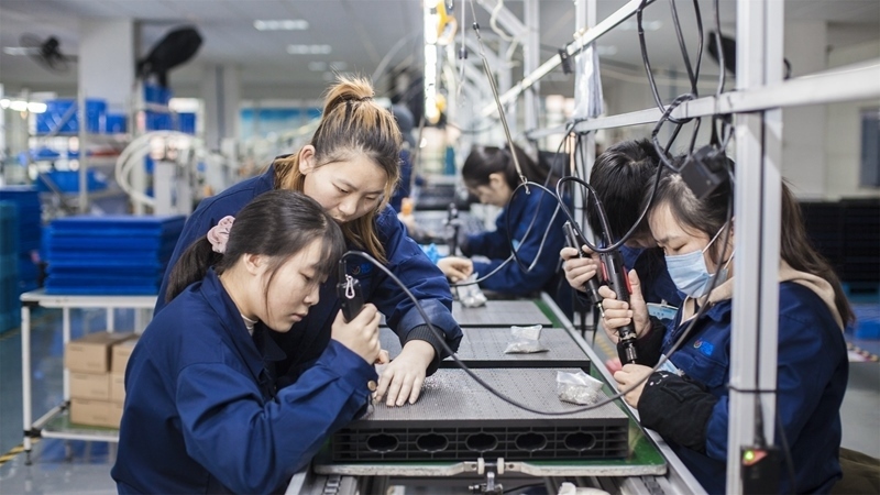 在新亞勝光電的產(chǎn)品線上，工人正進(jìn)行產(chǎn)品組建和安裝布線。受訪者供圖