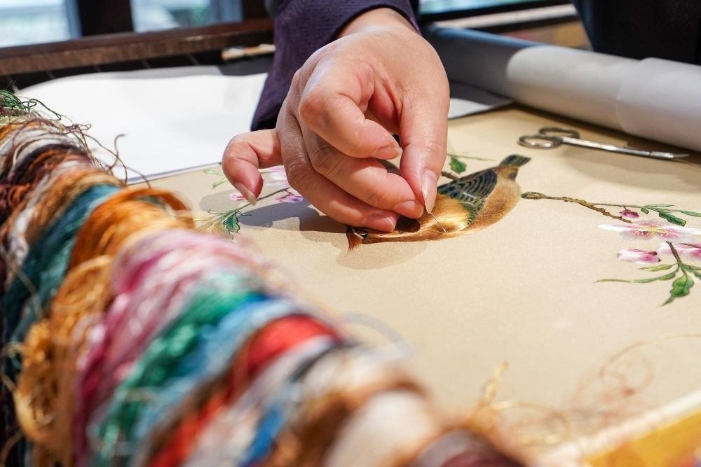 △2023年7月6日，盧建英在江蘇蘇州平江路的工作室內(nèi)刺繡。