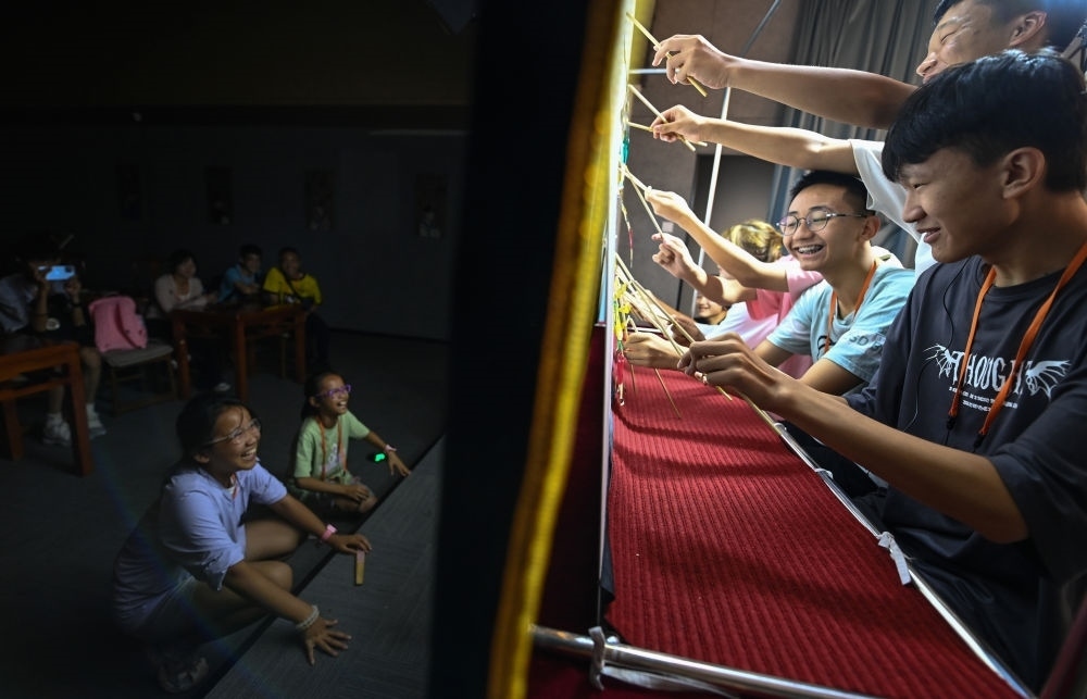 2023年8月8日，進(jìn)行暑期研學(xué)的學(xué)生在位于陜西省西安市的中國(guó)秦腔藝術(shù)博物館體驗(yàn)皮影戲演出。新華社記者 鄒競(jìng)一 攝