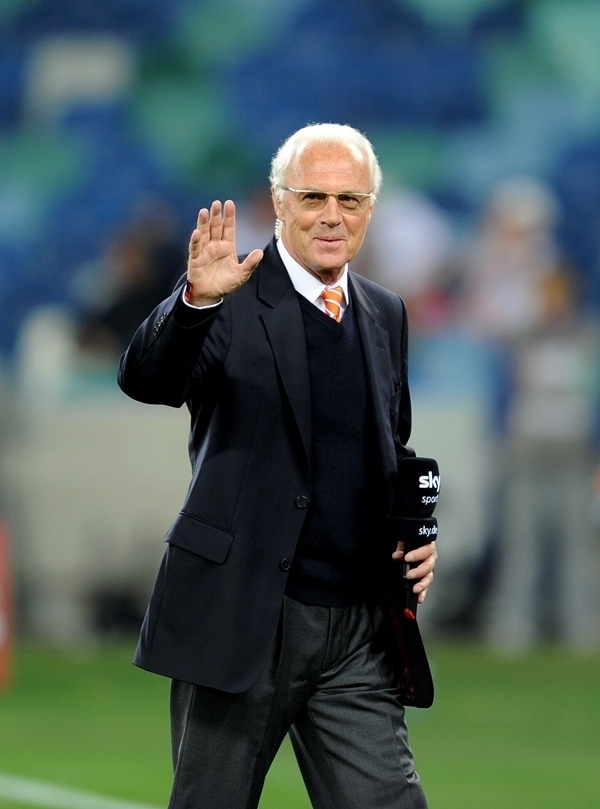 這是2010年7月7日，在南非德班舉行的2010年足球世界杯德國隊對陣西班牙隊的半決賽前，貝肯鮑爾接受電視臺采訪時和友人打招呼。新華社記者 王毓國 攝