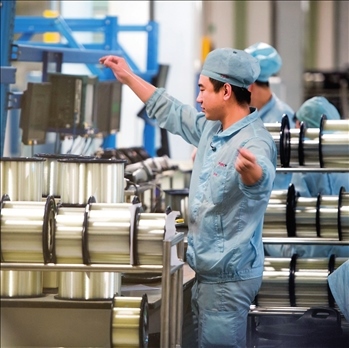 在位于武漢的長(zhǎng)飛光纖光纜股份有限公司光纖生產(chǎn)車(chē)間內(nèi)，工作人員對(duì)光纖進(jìn)行檢測(cè)（資料圖片）。肖藝九攝/本刊