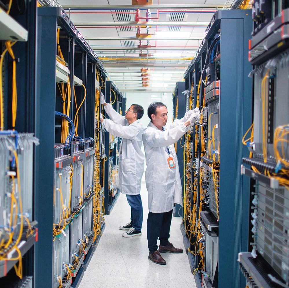 在位于武漢中國(guó)光谷的光電器件研發(fā)制造商——武漢光迅科技股份有限公司生產(chǎn)車(chē)間內(nèi)，技術(shù)人員在光模塊生產(chǎn)線(xiàn)作業(yè)（2023年4月11日攝）。程敏攝/本刊