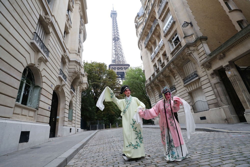 2023年9月13日，江蘇省演藝集團(tuán)昆劇院院長(zhǎng)施夏明（左）和江蘇省演藝集團(tuán)昆劇院國(guó)家一級(jí)演員孔愛(ài)萍在法國(guó)巴黎埃菲爾鐵塔附近參加昆曲快閃。新華社記者 高靜 攝