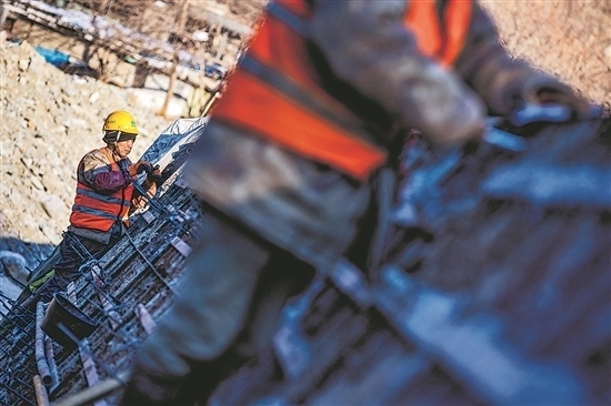 1月3日，房山區(qū)，工人正在雙泉河修筑堤壩。