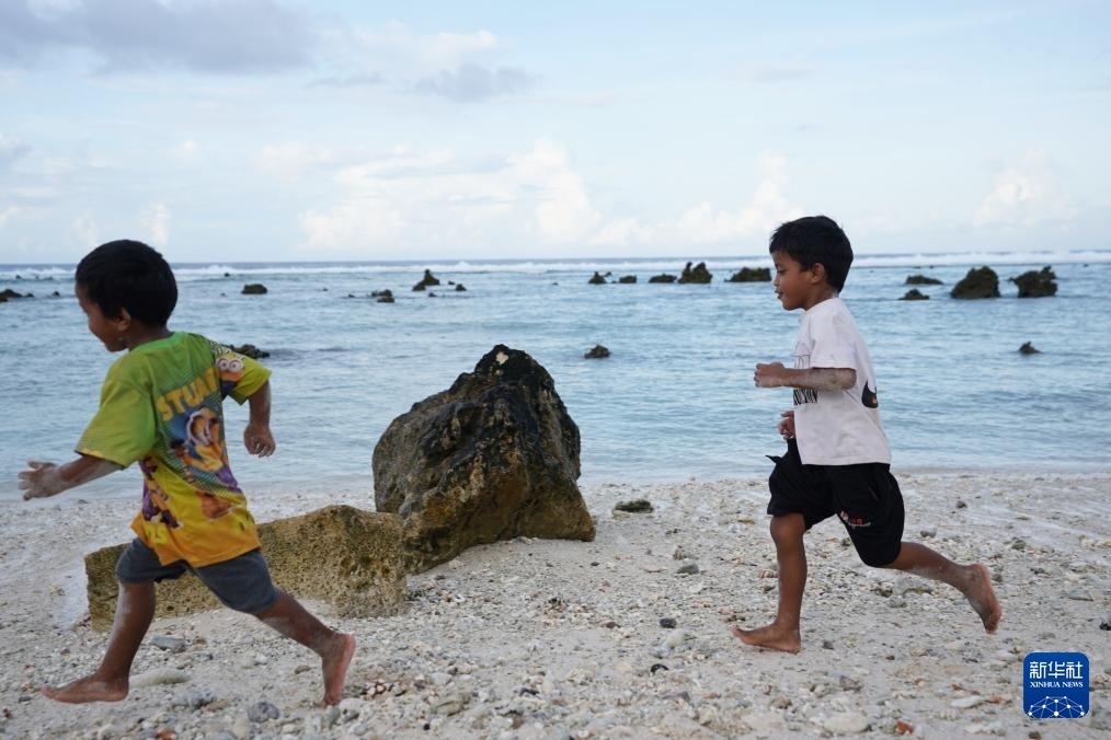 1月20日，兒童在瑙魯海邊嬉戲。新華社記者 王申 攝
