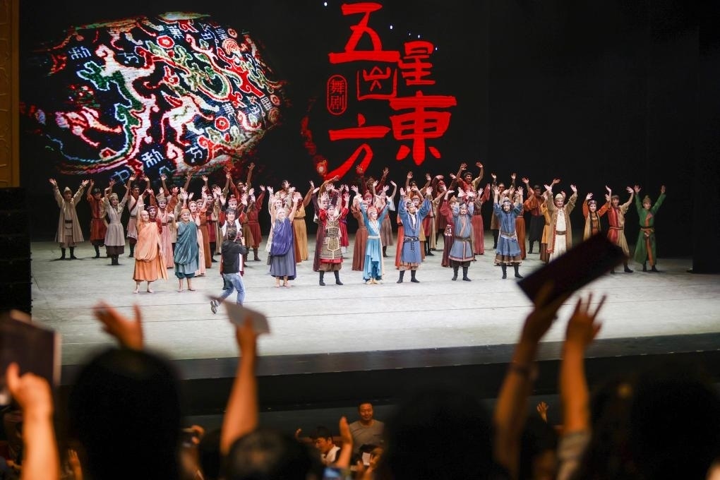 2023年7月31日，新疆和田地區(qū)新玉歌舞團(tuán)在烏魯木齊京劇院演出舞劇《五星出東方》后和觀眾互相揮手致意。這場演出是第六屆中國新疆國際民族舞蹈節(jié)的參演劇目之一，曾榮獲國家“文華獎(jiǎng)”等。新華社記者 郝昭 攝