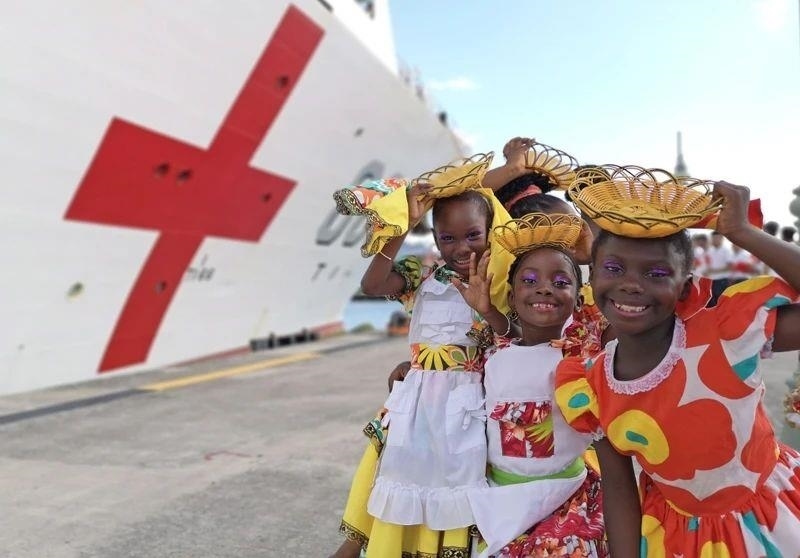 2018年10月，在安提瓜和巴布達首都圣約翰，當?shù)匦∨笥焉泶﹤鹘y(tǒng)服裝歡迎中國海軍“和平方舟”醫(yī)院船首次到訪。