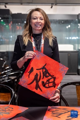 1月28日，在上海豫園舉行的民俗活動(dòng)上，美國(guó)馬斯卡廷初中校長(zhǎng)珍妮弗·李·弗里德利展示自己寫(xiě)下的“?！弊?。 新華社記者 王翔 攝