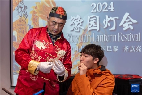 1月28日，在上海豫園舉行的民俗活動(dòng)上，美國(guó)馬斯卡廷中學(xué)學(xué)生在非遺傳承人的指導(dǎo)下吹糖偶。 新華社記者 王翔 攝