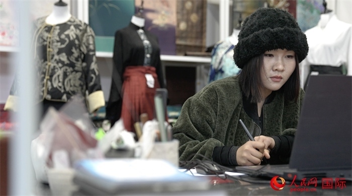 1月23日，在山東省菏澤市曹縣有愛云倉直播基地，張子晨正在設(shè)計漢服。 人民網(wǎng)記者 袁蒙攝