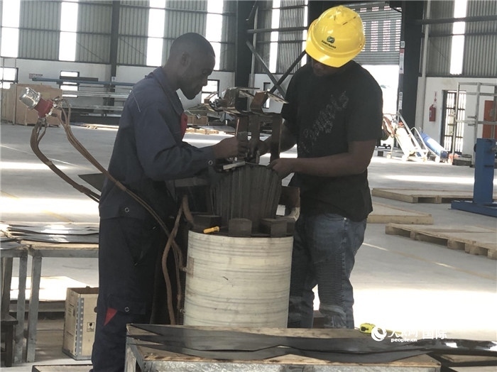 經(jīng)貿(mào)合作區(qū)廠房內(nèi)，當?shù)毓と苏诰o張作業(yè)。人民網(wǎng)記者 黃培昭攝