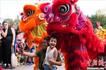 圖為舞獅表演吸引民眾合影。張興龍攝