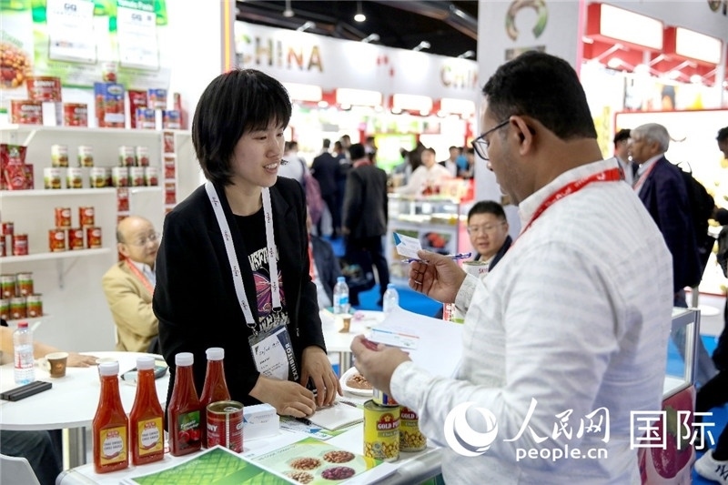 圖為中國參展企業(yè)代表與采購商交流。人民網(wǎng) 塔里克·易卜拉欣攝