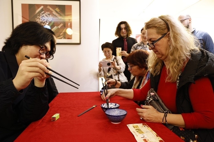 羅馬尼亞觀眾體驗用筷子夾花生。中國文化中心供圖