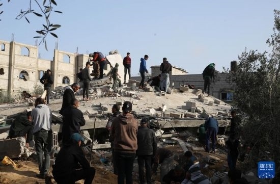  3月3日，在加沙地帶南部城市拉法，人們查看被以軍空襲破壞的建筑。新華社發(fā)（哈立德·奧馬爾攝）