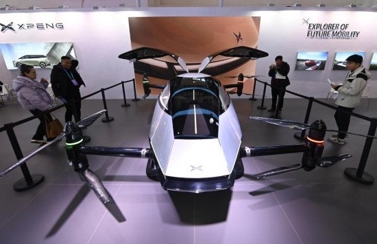 2023年12月1日，在鏈博會智能汽車鏈展區(qū)小鵬汽車展臺，參觀者觀看一臺智能飛行器。新華社記者蔡湘鑫攝