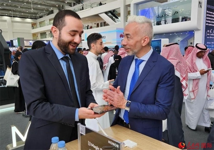 兩名觀眾在榮耀手機(jī)展臺前交流。人民網(wǎng)記者 管克江攝