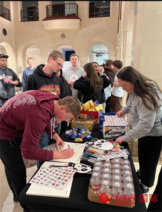 學(xué)生們出發(fā)前紛紛在留言簿留言。人民網(wǎng)記者 鄧圩攝