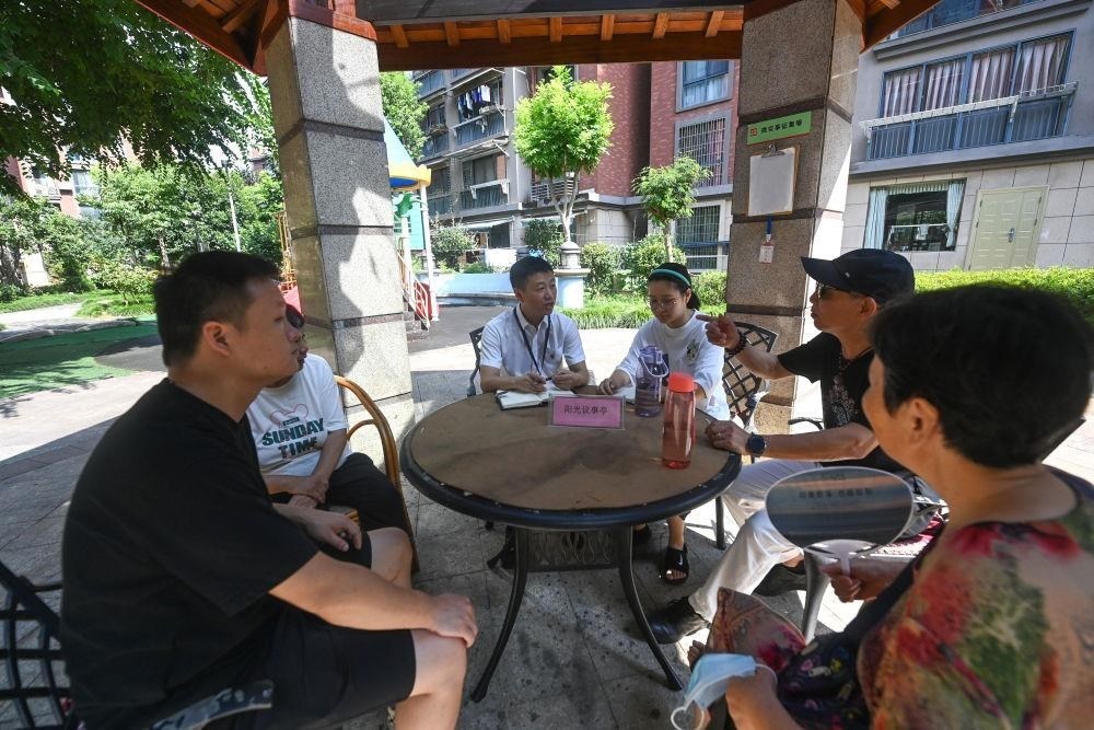 △2023年7月21日，在位于浙江杭州臨安區(qū)錦南街道水岸陽光小區(qū)的陽光議事廳，街道干部在聽取居民們反映的問題及意見。