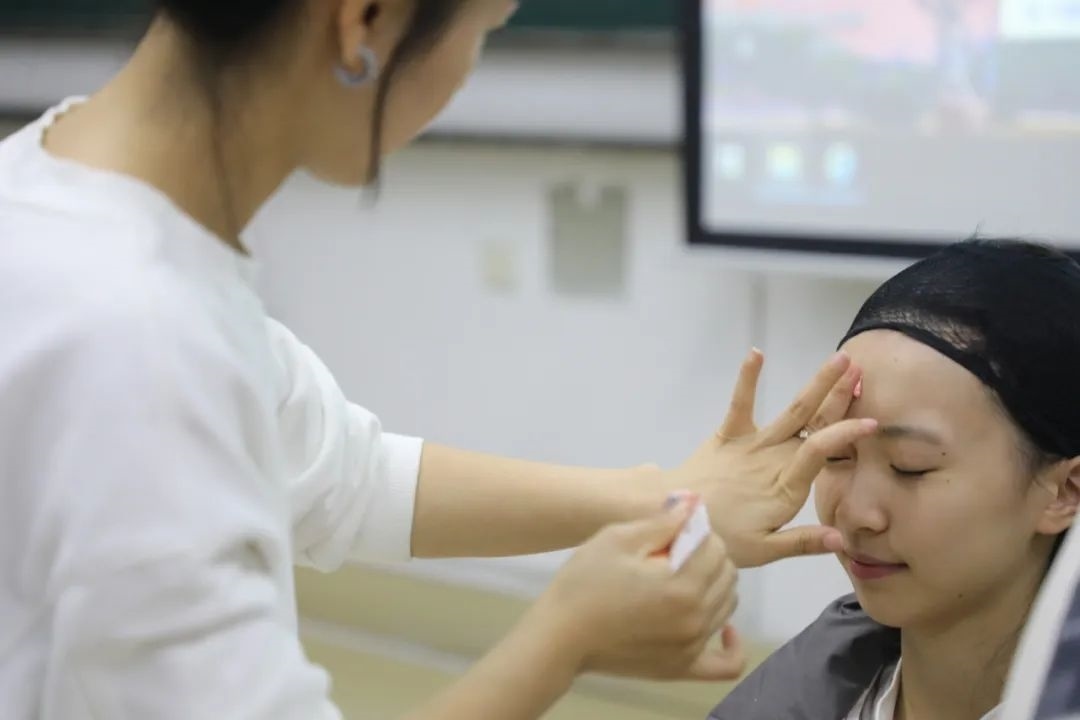 課堂上，一名學(xué)生在體驗(yàn)上戲妝。學(xué)校供圖