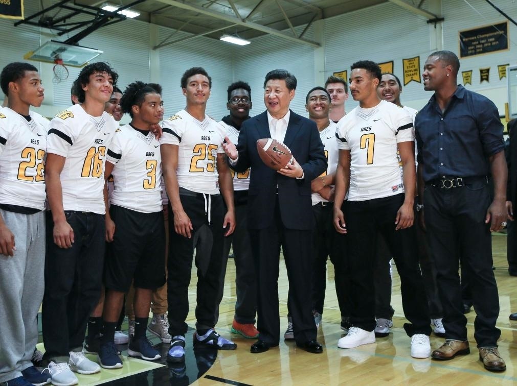 2015年9月23日，國家主席習(xí)近平參觀美國塔科馬市林肯中學(xué)。這是習(xí)近平在學(xué)校體育館，同上橄欖球訓(xùn)練課的學(xué)生們親切交談。新華社記者 蘭紅光 攝