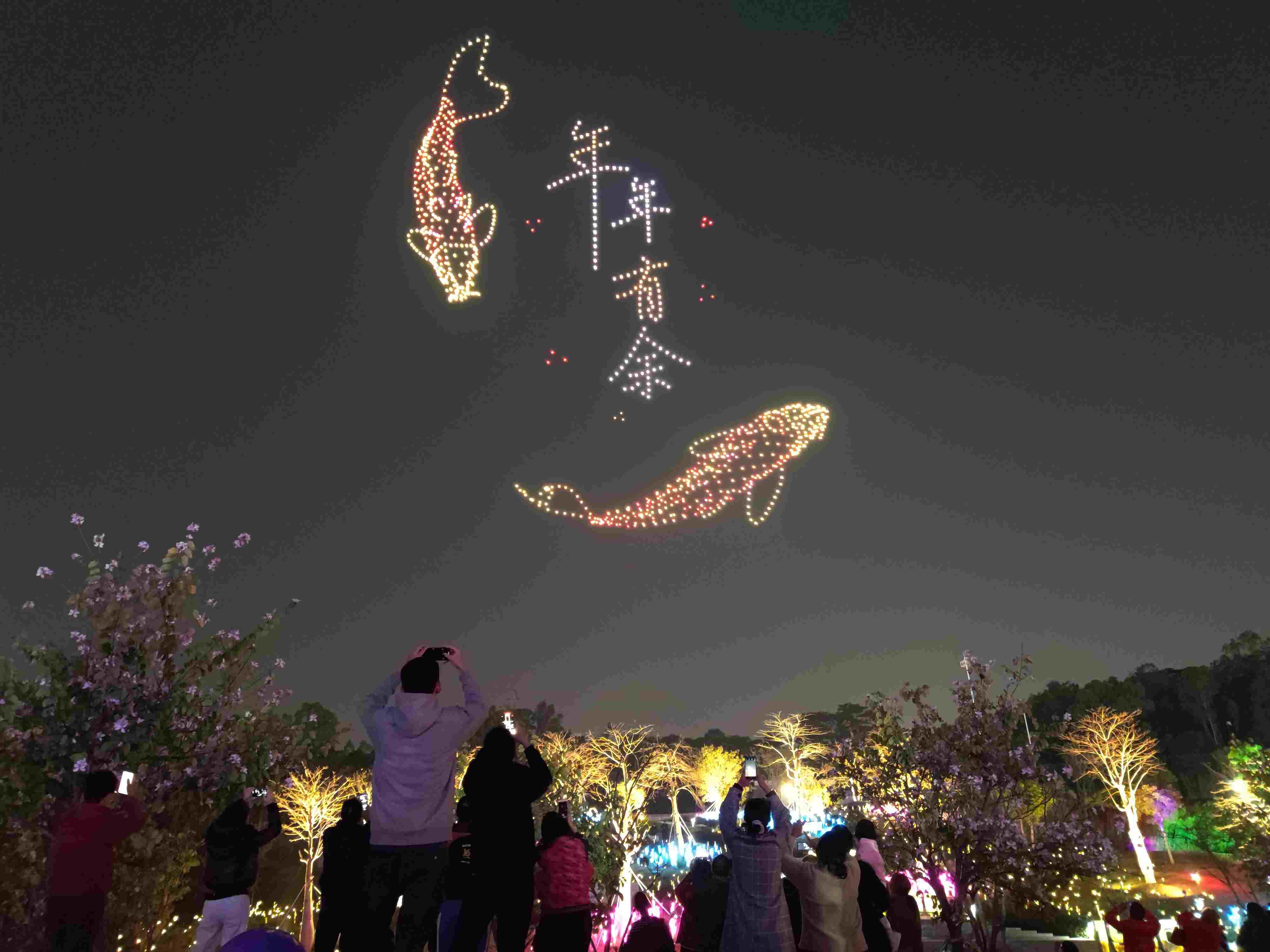 △ 2024年2月10日，深圳北站中心公園，春節(jié)主題無人機(jī)燈光秀引來眾多游客駐足觀看。