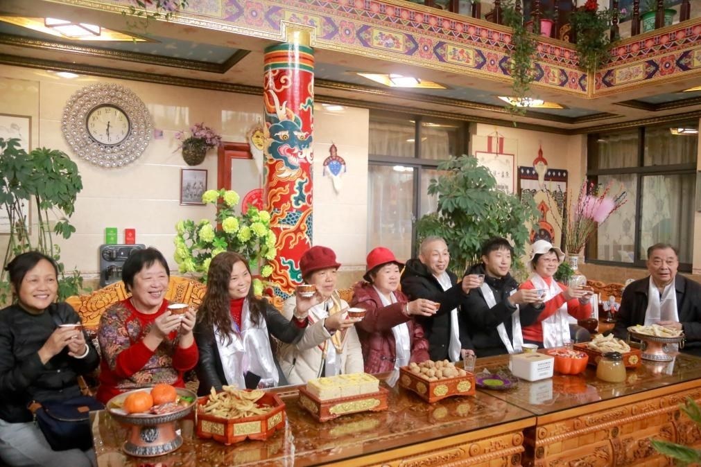 游客們?nèi)胱∶袼藓螅e杯共飲酥油茶。新華社記者 邱星翔 攝