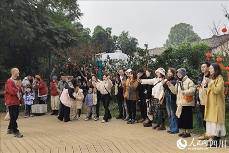 葉科（左一）給前來參與活動(dòng)的“柑爸柑媽”介紹生態(tài)種植果。人民網(wǎng)記者朱虹攝