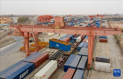 4月21日，二連浩特鐵路口岸龍門吊吊裝中歐班列集裝箱（無(wú)人機(jī)照片）。 新華社發(fā)（張海峰攝）