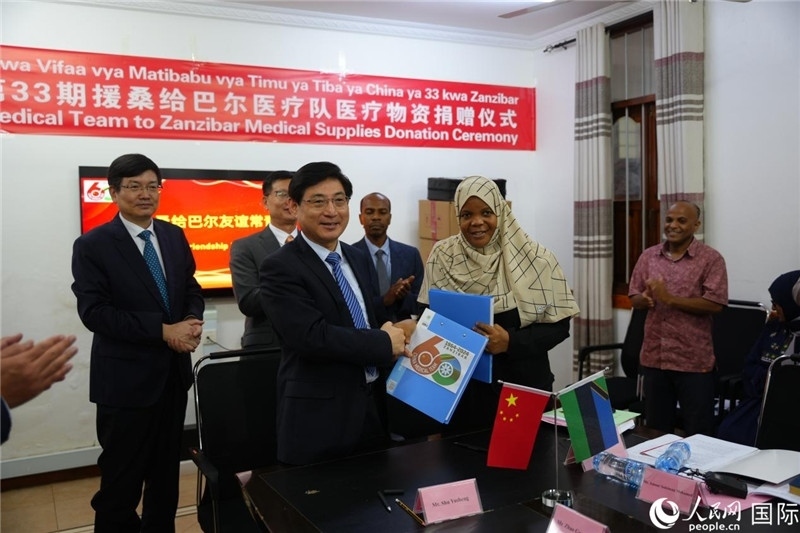 江蘇省蘇北人民醫(yī)院黨委書記束余聲與桑衛(wèi)生部首席秘書哈比巴交換捐贈(zèng)書。中國援桑醫(yī)療隊(duì)供圖