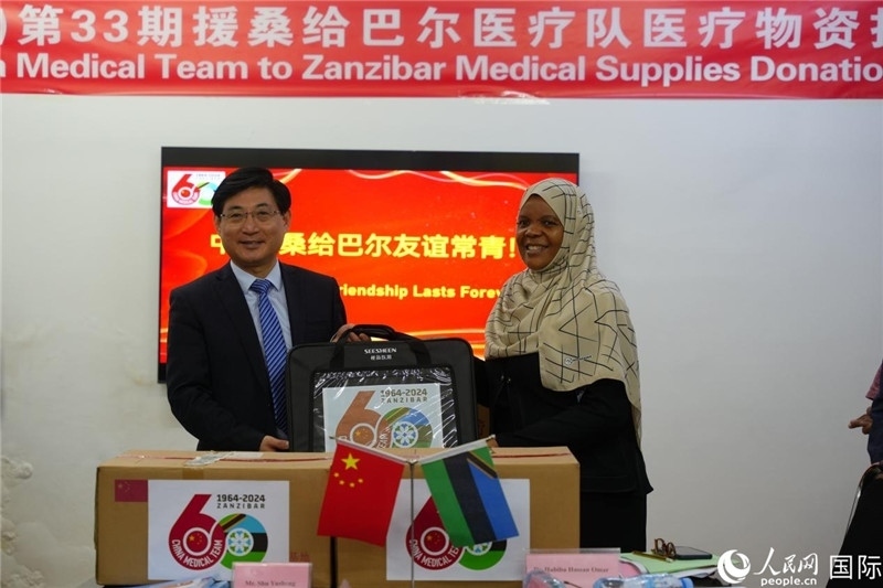 江蘇省蘇北人民醫(yī)院黨委書記束余聲捐贈(zèng)物資與桑衛(wèi)生部首席秘書哈比巴。中國援桑醫(yī)療隊(duì)供圖