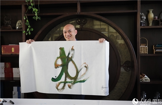 老撾駐華大使館三秘明君參加《五百筆·瀾湄合作》集體藝術(shù)創(chuàng)作。人民網(wǎng)王婧攝。