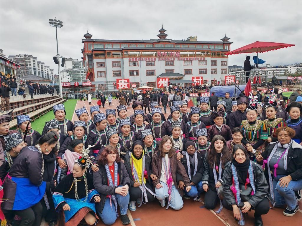 法國青年在“村超”賽場(chǎng)邊與參加表演的村民合影。新華社記者 羅羽 攝