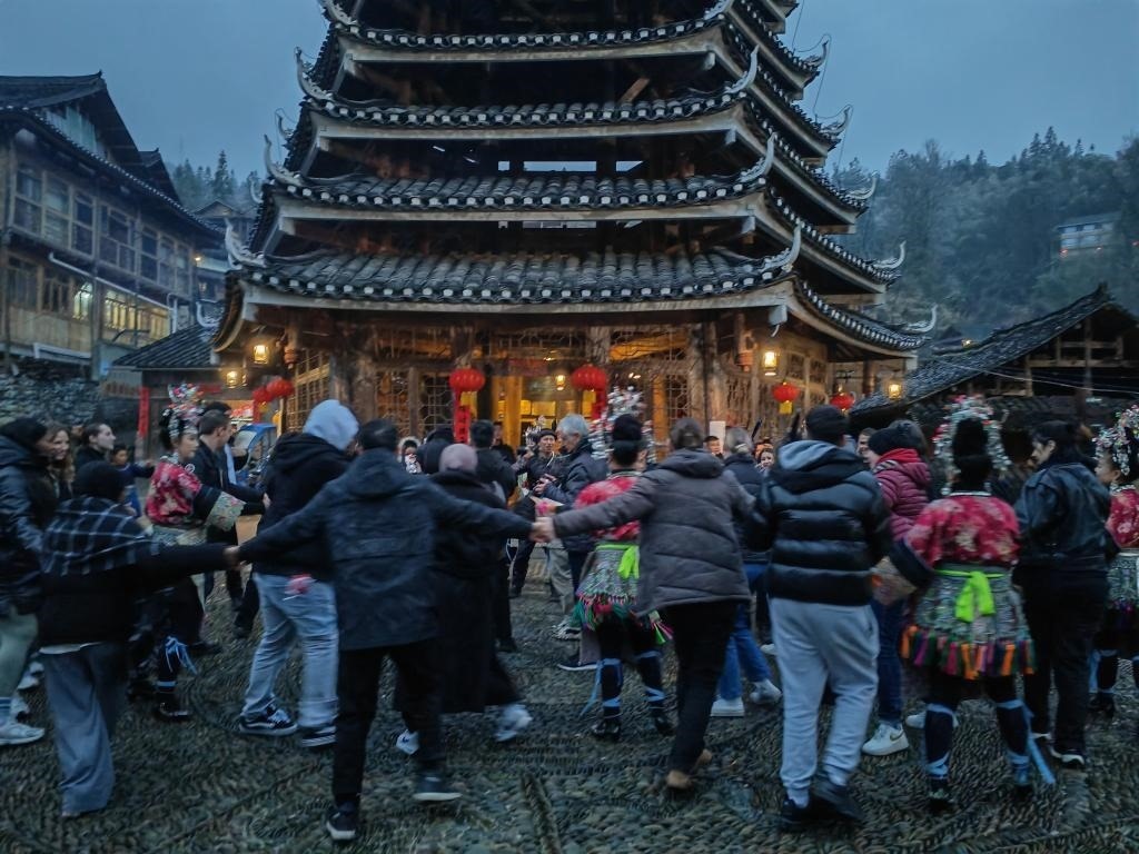 法國青年與當(dāng)?shù)卮迕駹渴痔?。新華社記者 羅羽 攝