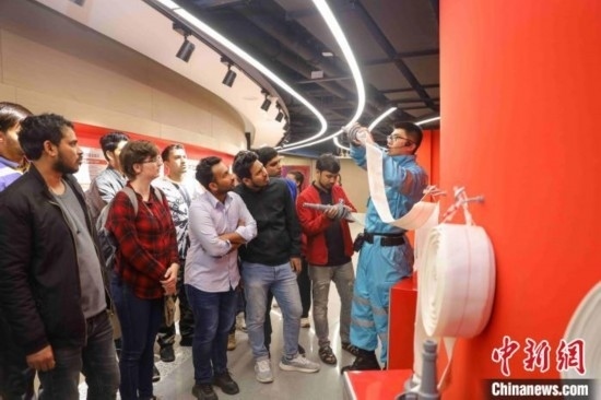 5月9日，工作人員指導留學生正確使用消防水帶。張鷹 攝