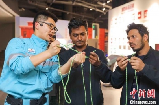 5月9日，工作人員指導留學生學習打繩結。張鷹 攝