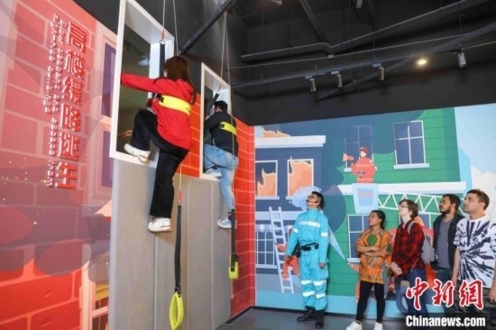 5月9日，留學生體驗模擬高樓緩降逃生。張鷹 攝