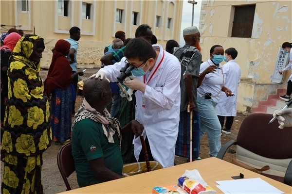 在義診現(xiàn)場，中國醫(yī)生與當(dāng)?shù)鼐用窈嫌傲裟?，吉布提鹽業(yè)投資公司供圖