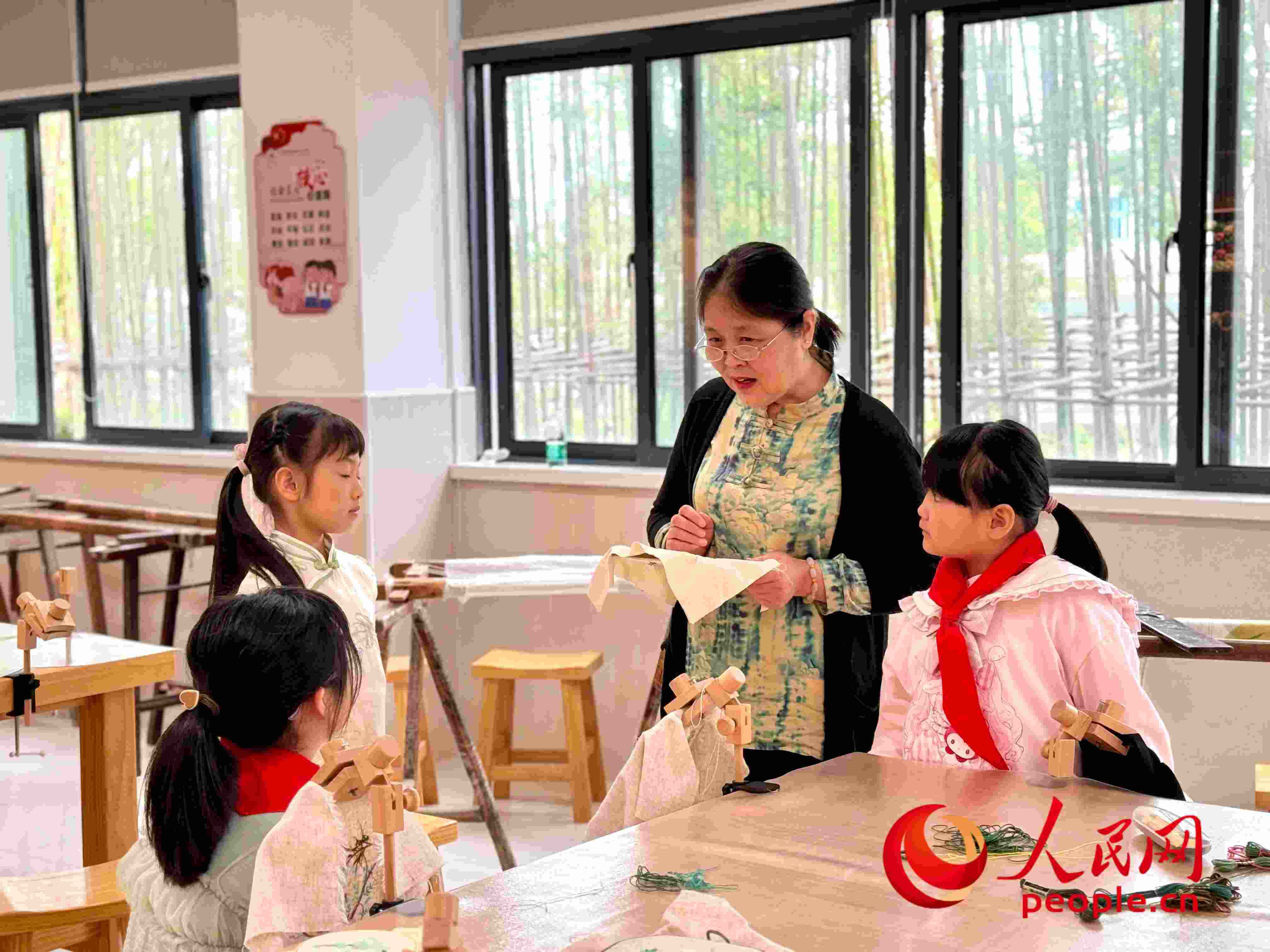 顧建珍（左三）在教孩子們刺繡知識(shí)。人民網(wǎng) 周靜圓攝