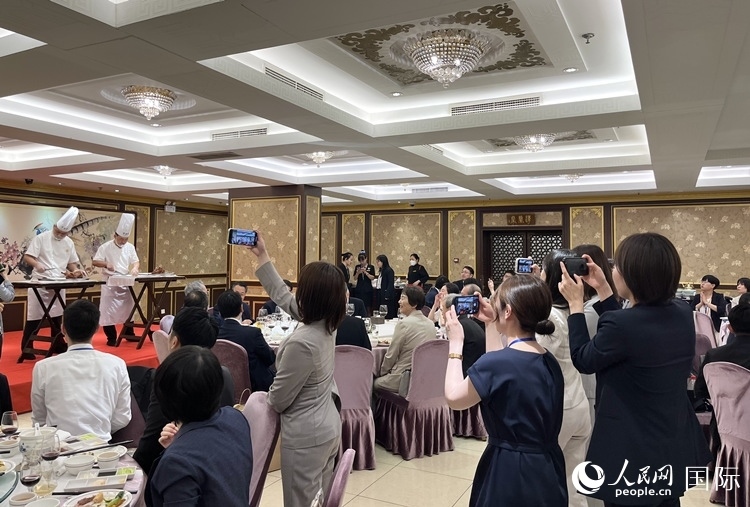 國家級非物質(zhì)文化遺產(chǎn)、全聚德片鴨工藝吸引代表團成員拍照留念。