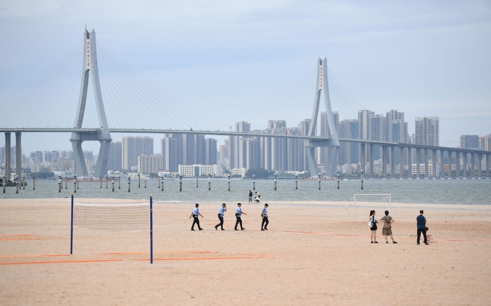 2023年7月17日，廣東湛江五環(huán)廣場的沙灘上，公安民警在執(zhí)勤巡邏。新華社記者 鄧華 攝