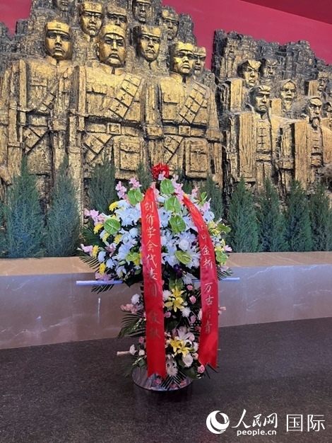 創(chuàng)價學(xué)會青年代表團(tuán)敬獻(xiàn)的花籃上，寫有“愿日中金橋萬古長青”。人民網(wǎng)記者 陳思攝