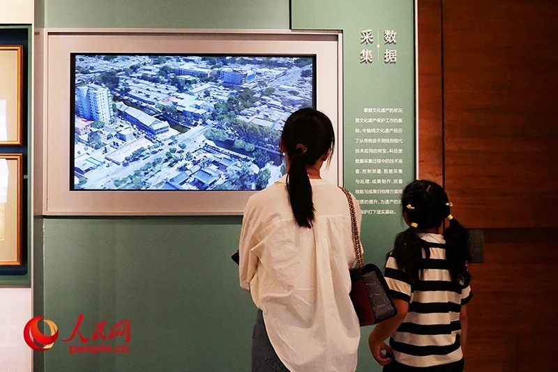 家長正在帶孩子參觀“輝煌中軸”專題展。人民網記者 韋衍行攝