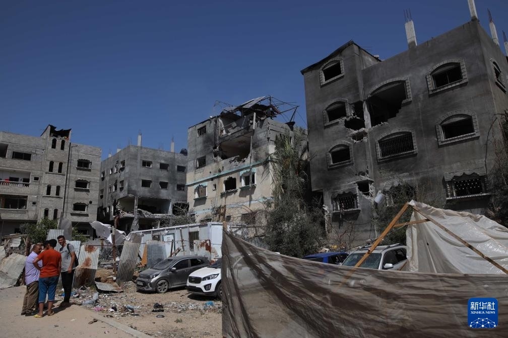 這是6月8日在加沙地帶中部努賽賴特難民營拍攝的在以軍襲擊中受損嚴(yán)重的房屋及車輛。新華社發(fā)（馬爾萬·達(dá)烏德攝）
