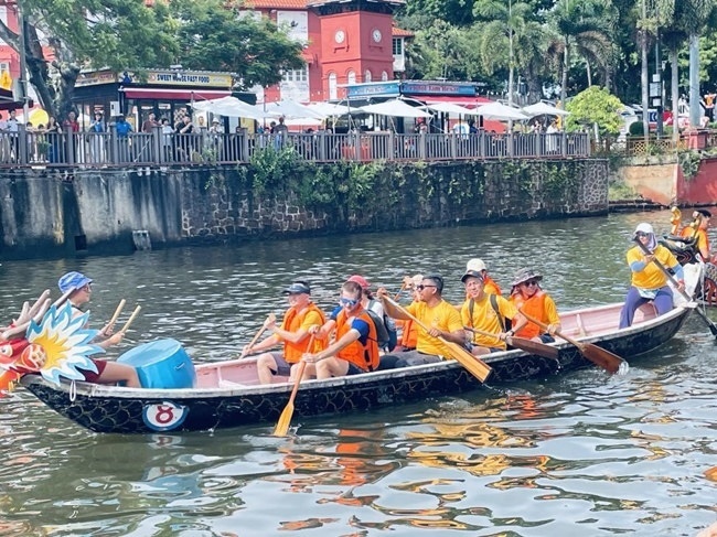 多元種族共同奮輯前進(jìn)，體驗(yàn)在馬六甲河劃龍舟，引來(lái)大批游客駐足圍觀。組委會(huì)供圖