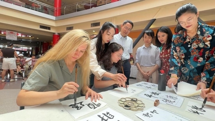 羅馬尼亞友人在活動(dòng)現(xiàn)場學(xué)寫漢字。中國駐羅馬尼亞大使館領(lǐng)僑處供圖
