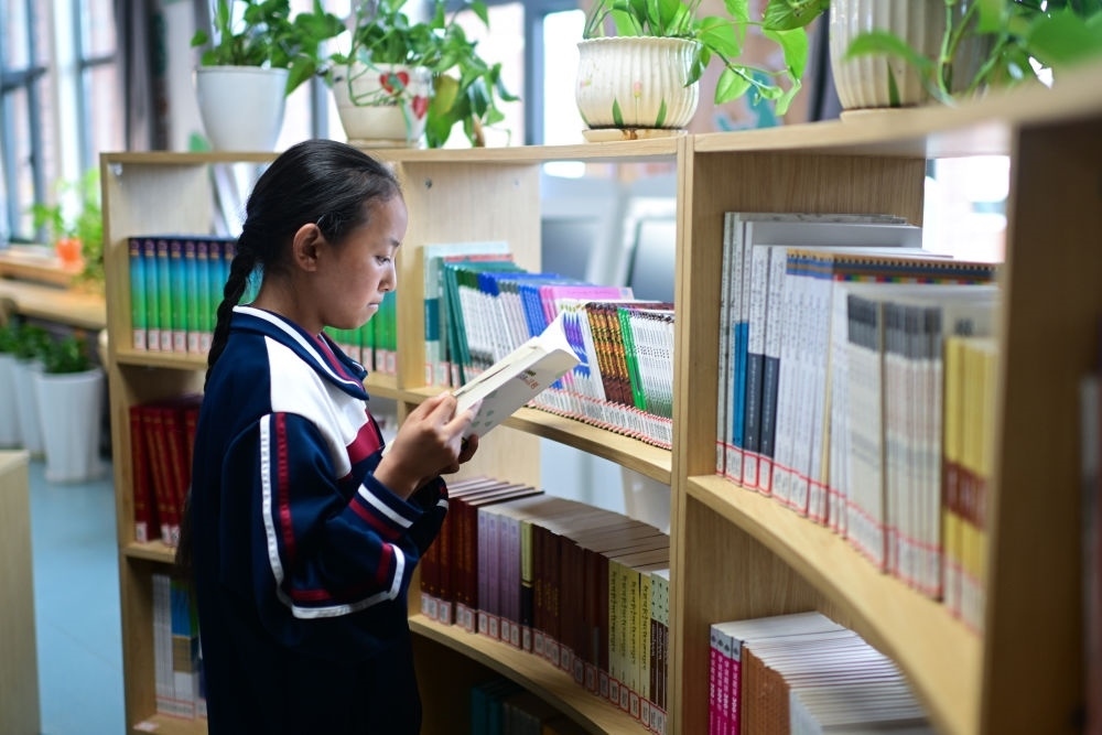 6月18日，果洛西寧民族中學(xué)學(xué)生尼東拉毛在圖書室看書。