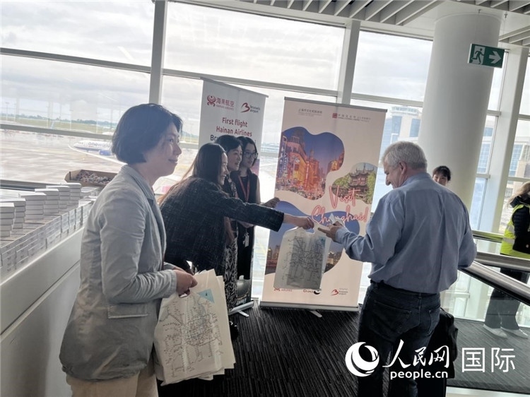 圖為工作人員向乘客發(fā)放復(fù)航首班禮物。 牛瑞飛攝