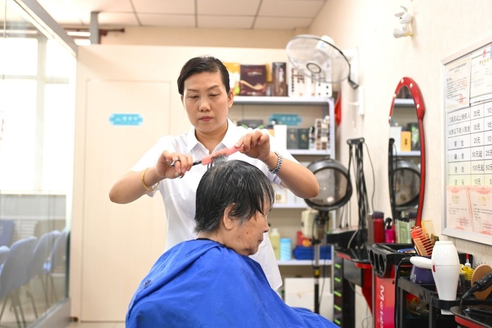 6月20日，長城花園社區(qū)的志愿者為居民理發(fā)。